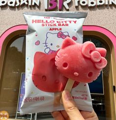 a hello kitty popsicle is being held up in front of a store