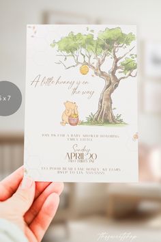 a person holding up a winnie the pooh baby shower card with honey on it