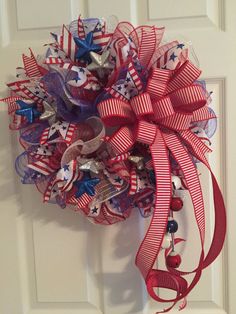 a red, white and blue wreath hanging on a door