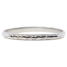 A hand engraved original Art Deco period wedding band in platinum. This ring features beautiful carved flowers throughout and a border of miligrain beading. In excellent condition, this ring is a size 8 US and measures 2mm across. Ring tests as platinum. Classic Silver Engraved Ring For Ceremonial Occasions, Classic Etched Round Band Jewelry, Classic Etched Jewelry With Round Band, Formal Etched Round Band Jewelry, Antique Engraved Wedding Ring With Carved Details, Classic Silver Carved Engraved Ring, Antique Carved Engraved Wedding Ring, Timeless Engraved Ring With Decorative Band, Classic White Gold Engraved Ceremonial Ring