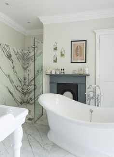 a white bathtub sitting next to a fireplace in a bathroom with marble floors and walls