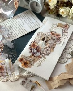 some cards and papers on a table with white flowers in the middle, one has an image of a woman