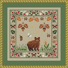 a cross stitch pattern with a bear in the grass and flowers on it's border