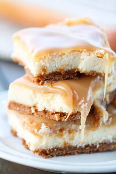 three pieces of cheesecake with caramel drizzled on top, sitting on a white plate