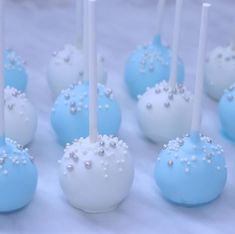 there are many blue and white cake pops on the table