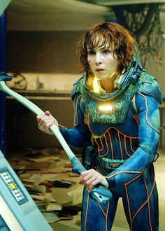 a woman dressed in blue and gold holding an ax