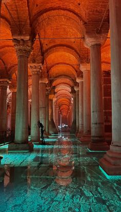 the inside of an old building with columns and lights