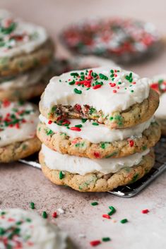 cookies with white frosting and sprinkles stacked on top of each other