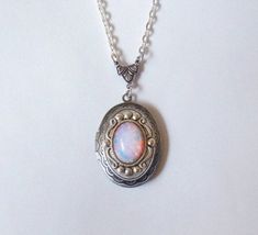 This lovely necklace is made using a vintage glass fire opal. The opal is high quality and features flashes of pink, orange, yellow, and even green... The glass is circular in shape with a flat back and domed front. It is attached to American made, antique silver setting. I set a stunning Beautiful Pink Opal Glass Cabs cabs in a classic oval locket in antiqued silver. The locket has a simple vintage-inspired design engraved on the front and back.  The locket is 1.25" X 1" (3 cm X 2.5 cm) with sp Vintage Opal Jewelry With Oval Cabochon, Vintage Oval Cabochon Opal Jewelry, Vintage Opal Oval Cabochon Jewelry, Handmade Vintage Opal Jewelry, Dragons Breath Fire Opal, Oval Locket Necklace, Bad Outfits, Toro Inoue, Necklace Photo