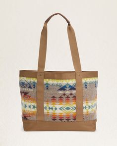 Elevate your travels or daily commute with our Highland Peak Zip Tote. Designed with a roomy zip-top and crafted with wool jacquard from our Pacific Northwest mills, this tote exudes distinctive style. The polyester canvas trim and leather handles add a touch of luxury, while the interior slip pocket provides practicality. Each piece is unique with varying pattern placements, making it truly one-of-a-kind. Loving the Highland Peak Design? Check out the matching backpack & crossbody bag. Highland Wool Tote Bag For Travel, Wool Travel Bags For Fall, Fall Travel Shoulder Bag With Leather Trim, Leather Trim Tote Shoulder Bag For Overnight Trips, Fall Travel Bags With Leather Trim, Fall Canvas Shoulder Bag With Leather Handles, Fall Canvas Bag With Leather Trim, Fall Canvas Bags With Leather Trim, Pendleton Bag