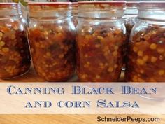 canning black bean and corn salsa in glass jars on a wooden table with text overlay reading canning black bean and corn salsa