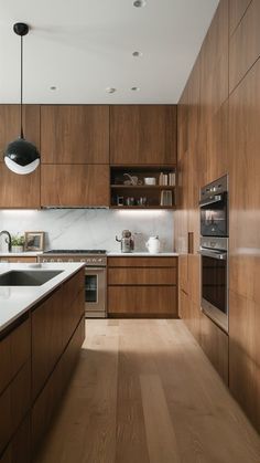 a modern kitchen with wooden cabinets and stainless steel appliance, along with marble counter tops