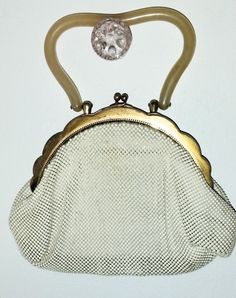 Highly collectible Whiting & Davis mesh bag in off-white with bakelite handle is in great condition. This is a lovely clutch that will dress up any outfit and is sure to get compliments! This bag is approximately 9" at its widest, 6" from closure to bottom, the handle is 5" wide and 3.5" tall. Black satin lining is in near-perfect condition. The Whiting & Davis Made in USA logo is visible inside the gold frame of the bag as well as the "2909" number. Vintage Cream Evening Bag, Cream Vintage Evening Bag, Cream Evening Bag With Detachable Handle, Vintage Cream Bags For Vintage Events, Vintage Cream Bags, Vintage Cream Bags For Formal Occasions, Vintage Cream Bag For Formal Occasions, Vintage Cream Formal Bag, Vintage Beige Evening Bag With Pearl Handle