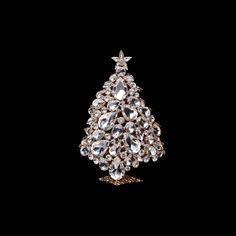 a crystal christmas tree brooch on a black background