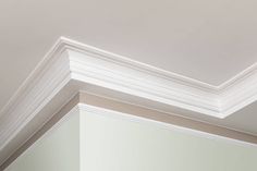 the corner of a room with white paint and molding on the ceiling above it