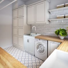 a washer and dryer in a white kitchen with wood counter tops on the floor