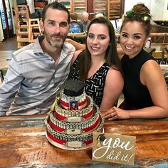 two people sitting at a table with a cake