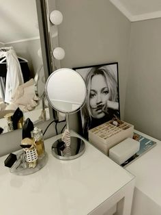 a vanity with a mirror, lamp and pictures on it