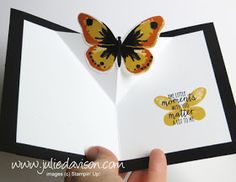 someone is holding an open card with a butterfly on it