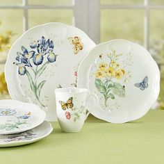 a table topped with plates and cups filled with flowers