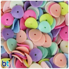 many different colored plastic buttons are stacked together