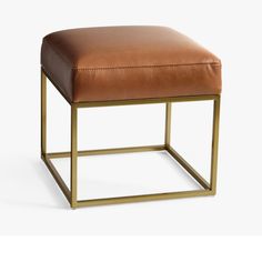 a brown leather stool with gold metal frame and square foot rest on a white background