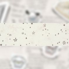 a white table topped with lots of stars on it's side next to cups and saucers