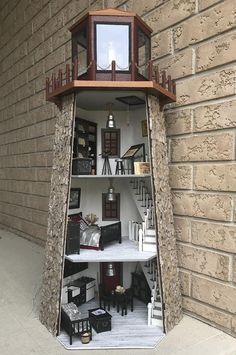 a doll house built into the side of a brick building with stairs leading up to it