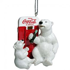 a coca cola machine ornament with two polar bears hanging from it's side