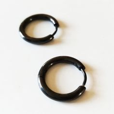 Simple Black Hoop Earrings for Men. These Black rings are made of high quality Steel. They are easy and comfortable to put on and take off. It is an earring that you can wear every day since it is very simple. It is a minimalist black circular hoop with an ideal size to wear on the earlobe as well as on the cartilage or the second hole. Its diameter is 16mm and its thickness is 3mm. You can buy a single unit or benefit from a good discount buying the pair. Choose your best option in the dropdown Black Hoop Earrings Men, Minimalist Black Round Cartilage Earrings, Modern Black Hypoallergenic Hoop Earrings, Everyday Black Single Hoop Earring, Black Round Cartilage Earrings For Everyday Wear, Black Small Hoop Cartilage Earrings For Everyday, Minimalist Black Hoop Cartilage Earrings, Black Minimalist Cartilage Earrings For Everyday, Modern Black Round Hoop Earrings