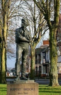 a statue of a man standing next to some trees