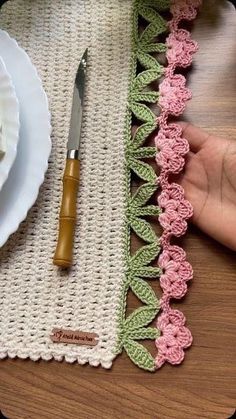 a crocheted placemat with a knife and fork on it next to a plate