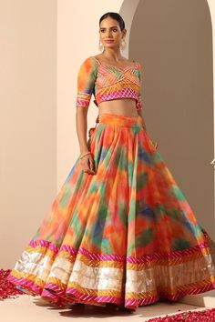 Orange lehenga with multi colored abstract patterns, lampi and gota patti border with side tassels. Comes with matching gota patti blouse with back tassel and dupatta.
Components: 3
Neckline: Sweetheart
Sleeve Type: Elbow
Fabric: Lehenga and Blouse: Georgette, Dupatta: Soft Net
Color: Orange
Other Details: 
Length:
Lehenga: 40 inches
Dupatta: 2.5 mtrs
Dupatta width: 44 inches
Note: Potli bag held by the model is not for sale
Occasion: Destination Wedding - Aza Fashions Gota Patti Blouse, Lehenga And Blouse, Orange Lehenga, Georgette Dupatta, Potli Bag, Lehenga Blouse, Potli Bags, Set For Women, Aza Fashion