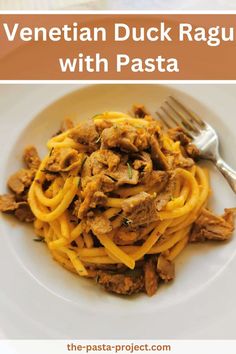 a white plate topped with pasta and meat next to a fork on top of a table