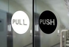 the words pull and push are reflected in glass doors