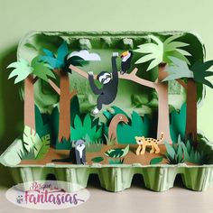 a cardboard box with animals and trees on the inside that is cut out to look like an origami