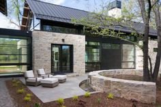 a modern house with stone walls and glass doors