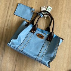 Nwt Vegan Leather Handbag Light Blue With Brown Handles And Silver And Gold Colored Decoration Comes With A Small Leather Wallet Sized Pouch Trendy Blue Hobo Bag With Top Handle, Trendy Blue Top Handle Hobo Bag, Light Blue Large Capacity Satchel For Everyday Use, Everyday Use Light Blue Large Capacity Satchel, Faux Leather Satchel With Snap Closure, Light Blue Satchel With Detachable Handle For Everyday Use, Blue Faux Leather Shoulder Bag For Everyday Use, Blue Faux Leather Shoulder Bag, Casual Blue Satchel With Detachable Handle