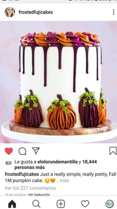 a white cake with purple icing and pumpkins on top