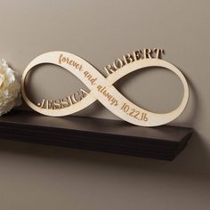 a couple of wooden signs sitting on top of a shelf next to a white flower