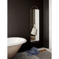 a white sink sitting next to a bath tub in a room with black walls and flooring