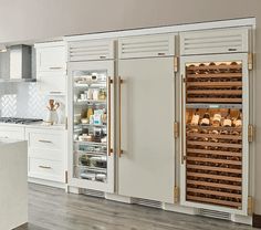 a kitchen with white cabinets and wooden floors