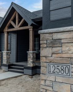 a house that is made out of stone and has a number plate on the front