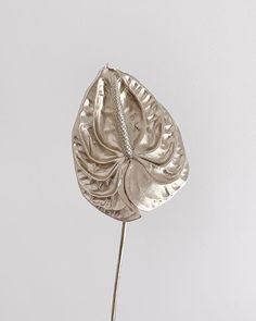 a silver flower on top of a white table