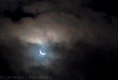 the moon is partially obscured by dark clouds