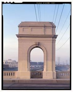 an arch on the side of a road with power lines in the background