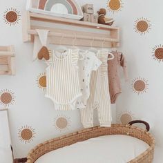 a baby crib with clothes hanging on the wall