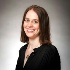 a woman in black shirt smiling at the camera