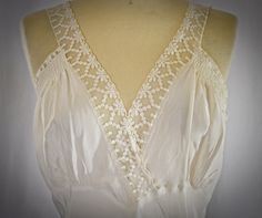 A vintage 1940s long ivory rayon or rayon/silk blend sleeveless nightie with wide lace trim and ruching detail at the bust.  The gown has a V neckline both front and back.  The front neck edge is trimmed with 1 1/2 inch wide sheer floral lace.  The front armhole area has gathered rows of ruching and is trimmed with narrow  matching lace.  There is a curved and pointed seam and gathers under the bust.  The skirt is fitted through the waist and hips and gently flared.  I found one very pale brown Sleeveless Lace Bodice Nightgown For Summer, Sleeveless Bias-cut Nightgown, Sleeveless Bias Cut Nightgown, Sleeveless Nightgown With Lace Bodice, Sleeveless Cream Nightgown For Wedding, Sleeveless Spring Wedding Nightgown, Spring Sleeveless Wedding Nightgown, Sleeveless Nightgown For Wedding In Spring, Vintage Sleeveless Cream Nightgown