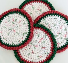 four crocheted coasters with red, green and white designs